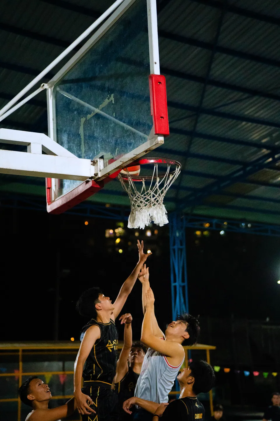 Outdoor basketball under floodlights at night