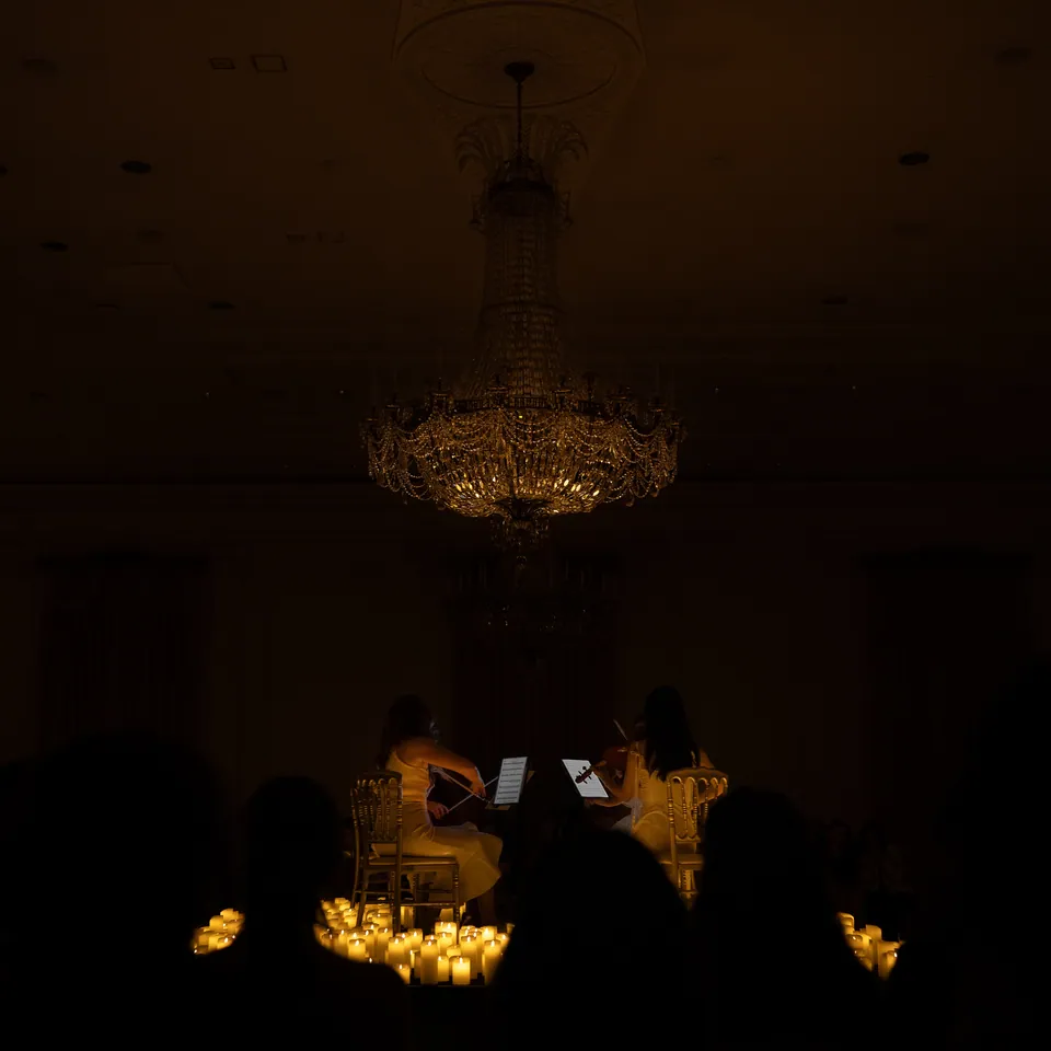 Chandelier above a candlelit room in near darkness