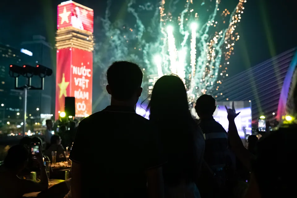Silhouetted couple watching fireworks over a city