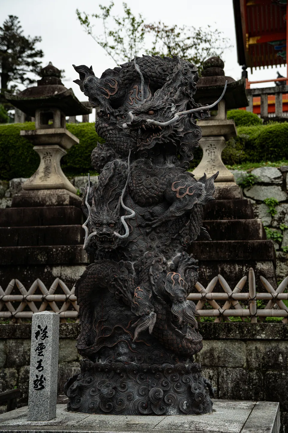 Stone dragon statue beside stone lanterns